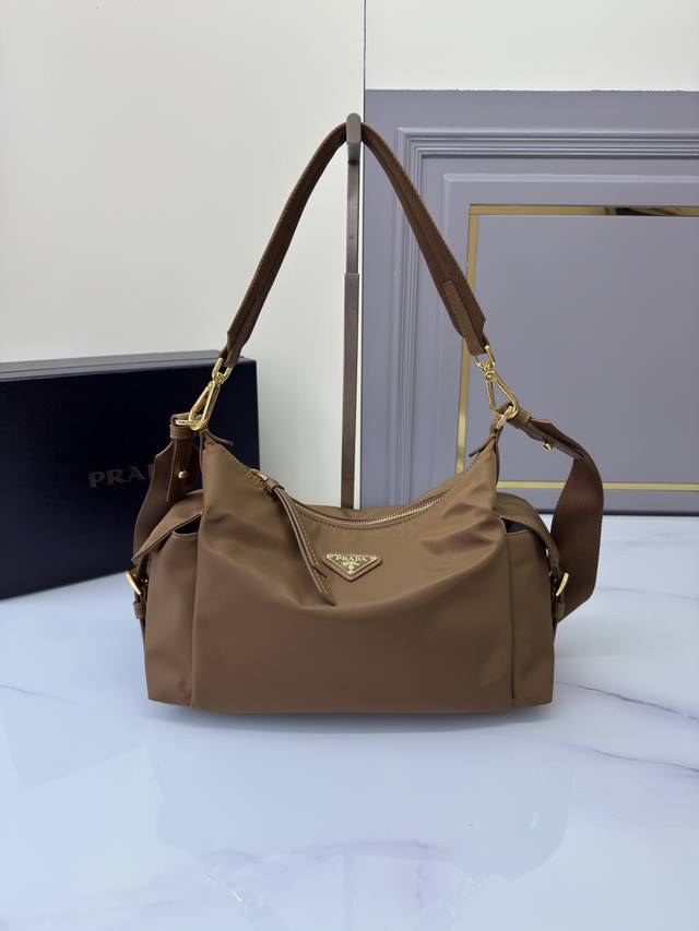 新品1Bc264探索包 这款探索包采用进口尼龙面料和小牛皮，具有柔软的轮廓和多个口袋。轻质实用的Re-Nylon强调了设计的多功能风格，而皮革细节和标志性点缀则