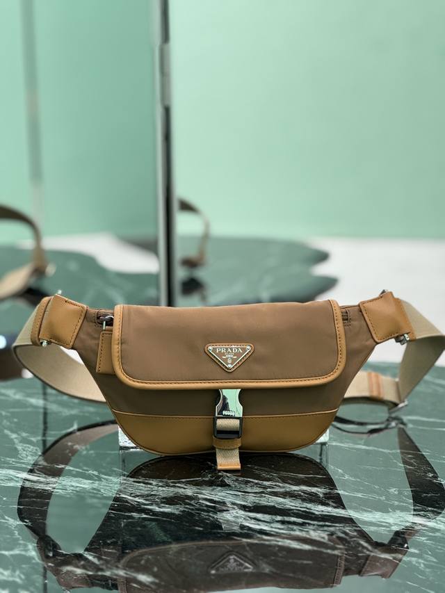 男士胸包 这款百搭时尚单肩包采用进口尼龙材质。小巧款型点缀皮革饰边，侧面插扣等细节精致而实用，可调节肩带便于斜挎。涂珐琅三角形金属徽标彰显品牌经典特色。又可当胸