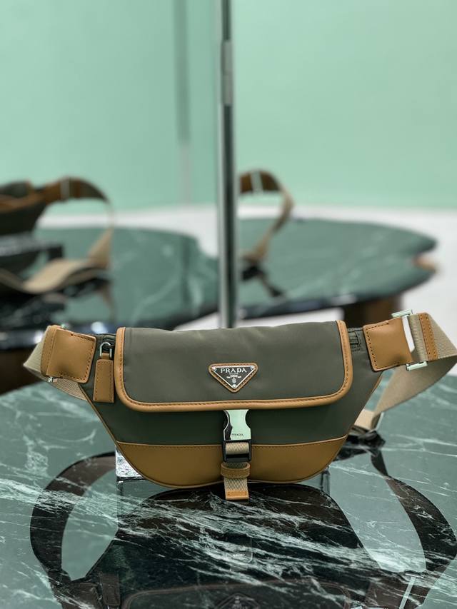 男士胸包 这款百搭时尚单肩包采用进口尼龙材质。小巧款型点缀皮革饰边，侧面插扣等细节精致而实用，可调节肩带便于斜挎。涂珐琅三角形金属徽标彰显品牌经典特色。又可当胸