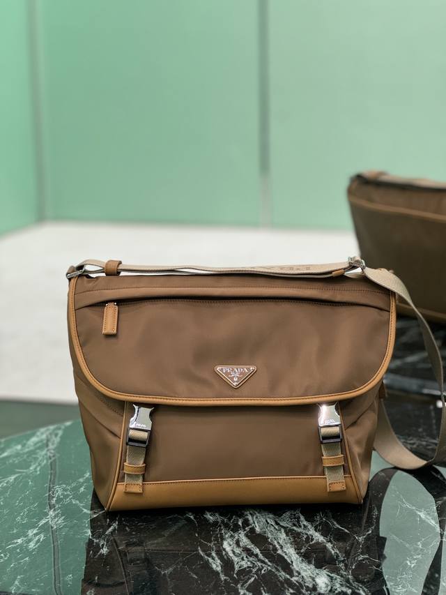 新款邮差包 这款邮差包由Re-Nylon再生尼龙面料设计，翻盖和按锁开合，三个外部拉链式口袋，内部拉链式口袋和贴袋。容量空间大，又是一款永久不过时爆款。帅哥们，