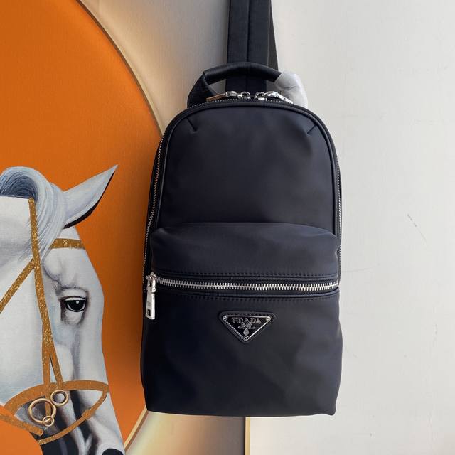 最新款男士背包，最新款背包胸包，采用进口Saffiano皮革材质和进口尼龙布料，可调式尼龙肩带，拉丝金属配件，这款尼龙背包多个口袋和加衬背部设计颇具设计特色。轻