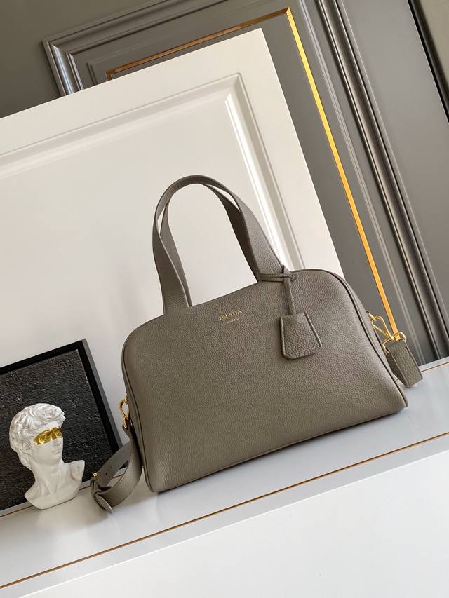 新款 这款天然粒面皮革制成的顶部提手包袋以柔软的轮廓进行了重新诠释，可手提或搭配可拆式肩带佩戴，配有2个可拆卸吊牌。金属硬件。正面带有浮雕字母标志，拉链封口，带