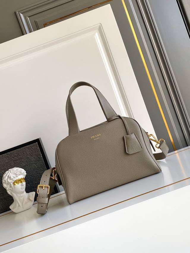 新款 这款天然粒面皮革制成的顶部提手包袋以柔软的轮廓进行了重新诠释，可手提或搭配可拆式肩带佩戴，配有2个可拆卸吊牌。金属硬件。正面带有浮雕字母标志，拉链封口，带