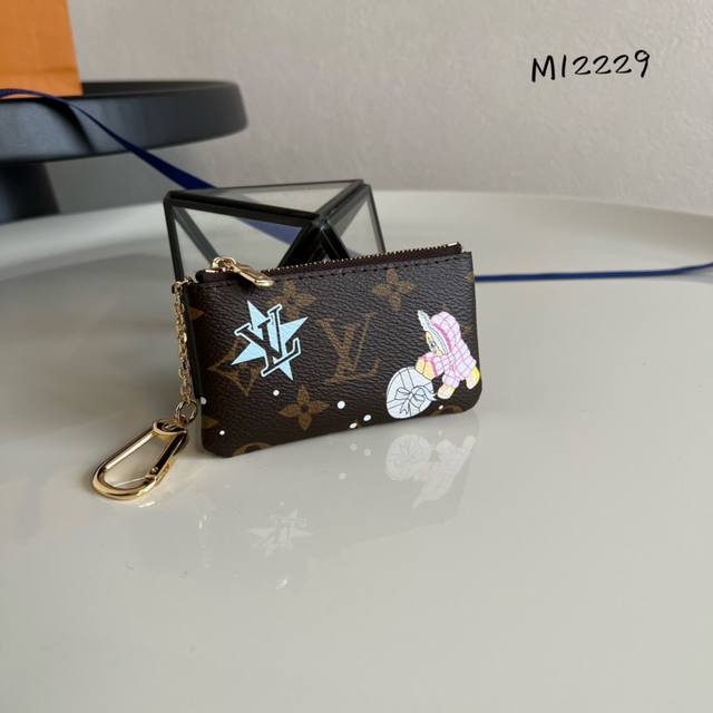 出厂价 芯片版 顶级原单 M12229 由内至外魅力难挡的钥匙包,Monogram 印花表面描绘品牌吉祥物 Vivienne 与好友在热带海滨乘船玩耍的场景,粒 出厂价 芯片版 顶级原单 M12229 由内至外魅力难挡的钥匙包,Monogram 印花表面描绘品牌吉祥物 Vivienne 与好友在热带海滨乘船玩耍的场景,粒